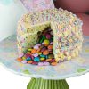 Colourful gourmet rainbow pinata celebration cake revealing chocolate candies