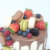 Top of luxury celebration cake with freshly baked macarons and fruits
