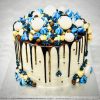 Extravagant gourmet celebration cake with blue and gold ganache drip, macarons and meringues
