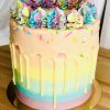 Handcrafted rainbow pinata cake, with colour sprinkles and vanilla drip detail