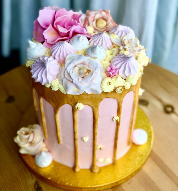 Showstopping handcrafted pink and gold birthday cake with pink meringues and gold ganache drip