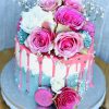 Stunning pink, blue and white gourmet birthday cake with fresh pink flowers and pink macarons